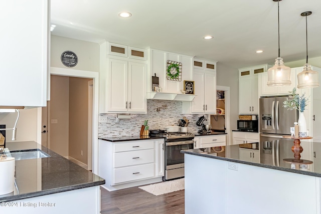 kitchen featuring white cabinets, glass insert cabinets, stainless steel appliances, and hanging light fixtures