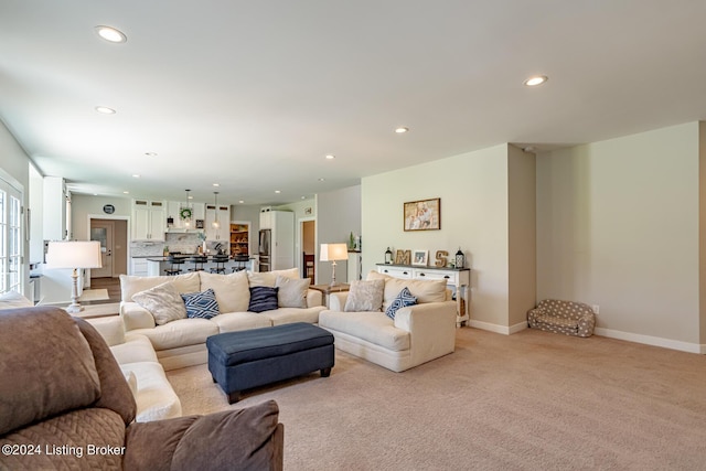 living area featuring recessed lighting, light colored carpet, and baseboards