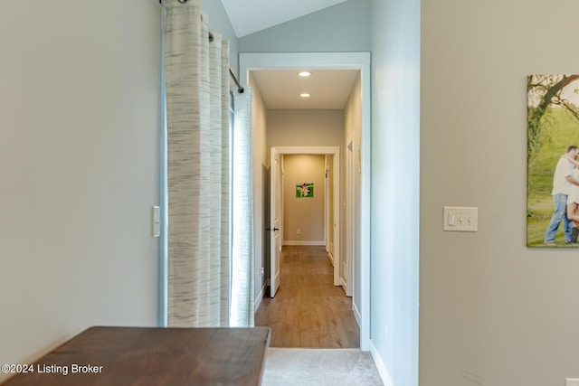 hall with lofted ceiling, baseboards, and recessed lighting