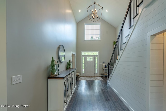 entryway with dark wood-style floors, high vaulted ceiling, stairway, and a notable chandelier