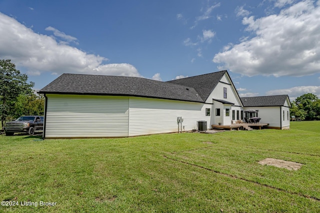 view of side of property with a yard, central AC unit, and a wooden deck