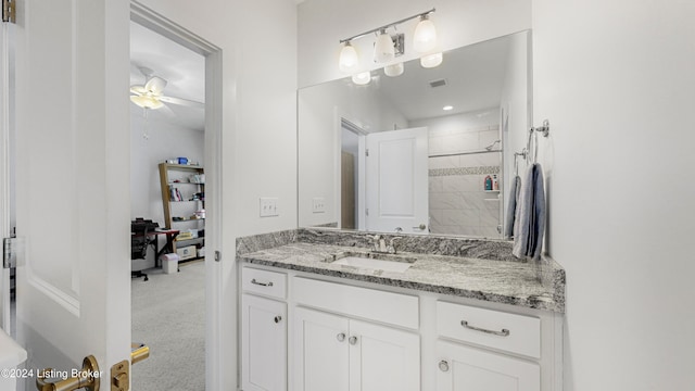 bathroom with vanity, tiled shower, and ceiling fan