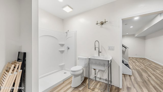 bathroom featuring a shower, toilet, sink, and wood-type flooring