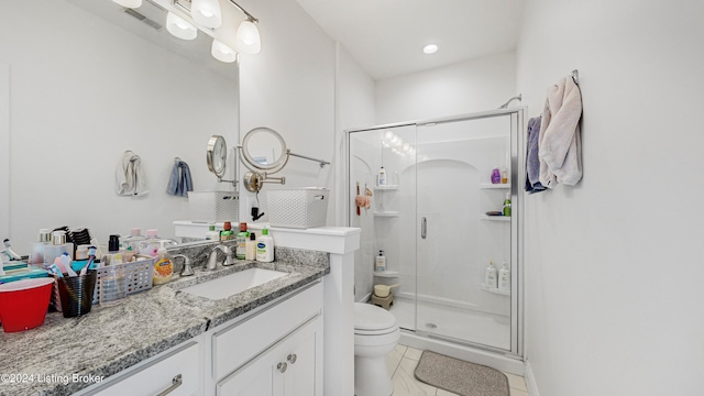 bathroom featuring tile patterned flooring, vanity, toilet, and walk in shower