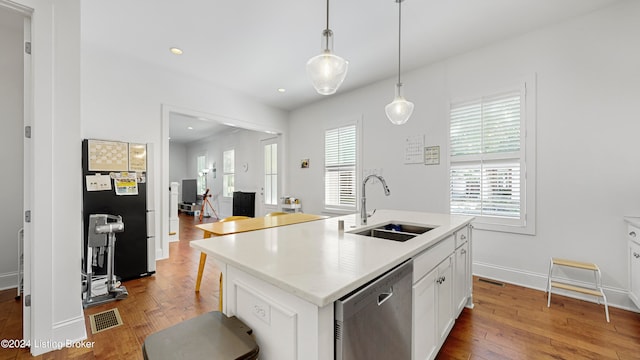 kitchen with appliances with stainless steel finishes, plenty of natural light, an island with sink, and light hardwood / wood-style flooring