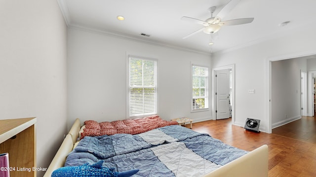 bedroom featuring crown molding, ceiling fan, hardwood / wood-style floors, and multiple windows