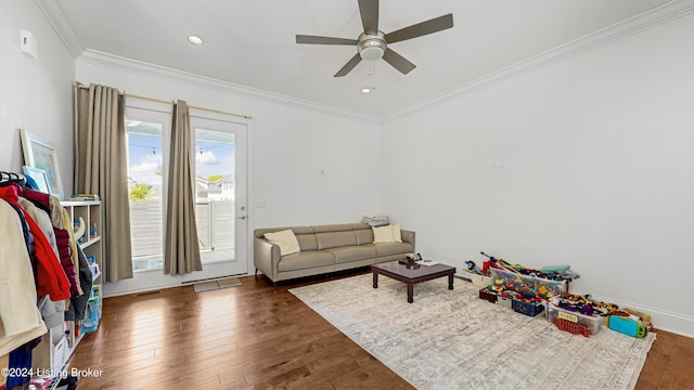 game room with crown molding, dark hardwood / wood-style flooring, and ceiling fan