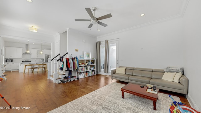 living room with crown molding, wood-type flooring, and ceiling fan