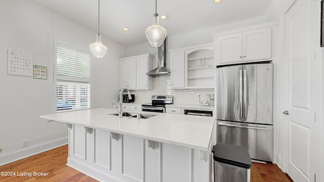 kitchen with stainless steel appliances, hardwood / wood-style floors, white cabinetry, and decorative light fixtures