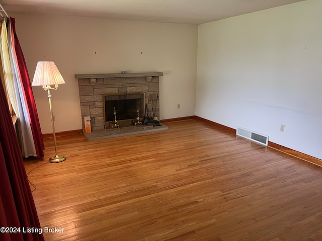 unfurnished living room featuring a fireplace and wood-type flooring