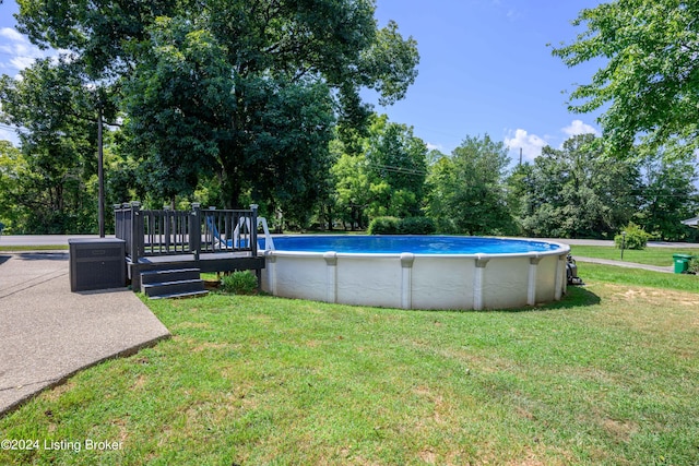 view of pool with a wooden deck and a yard