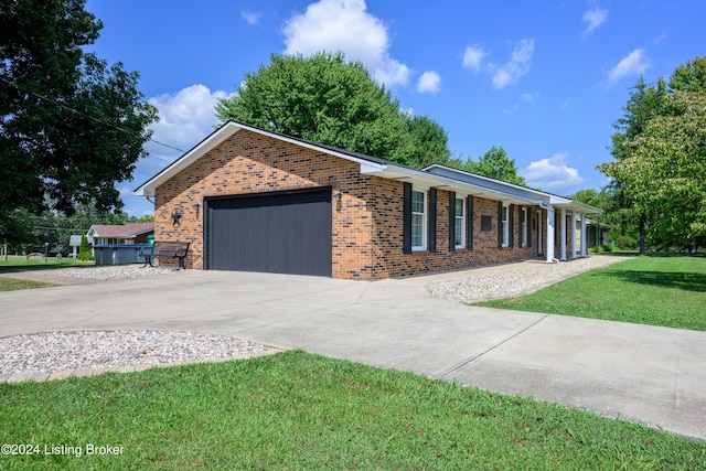 ranch-style home with a garage and a front lawn