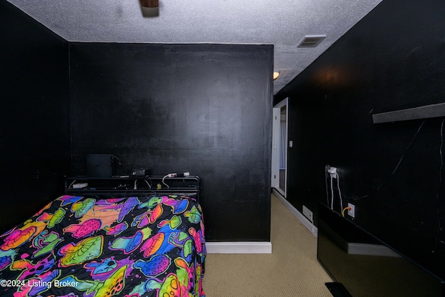 bedroom with light colored carpet and a textured ceiling