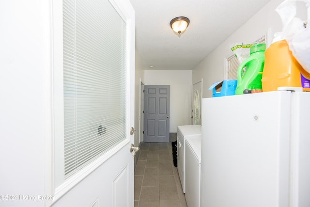 laundry room with light tile patterned floors and washer and clothes dryer