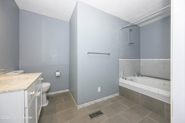 bathroom featuring tile patterned floors, toilet, a textured ceiling, and vanity