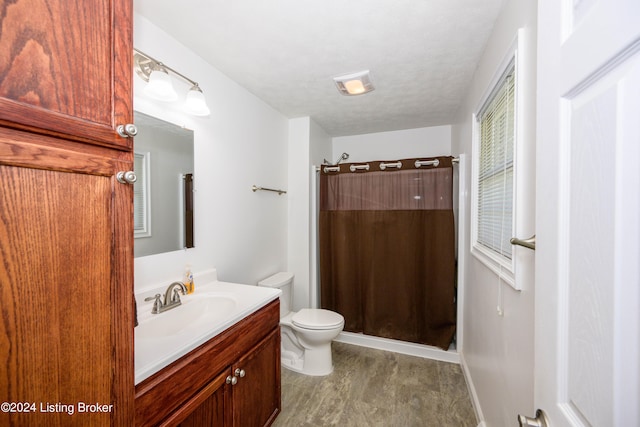 bathroom featuring toilet, a textured ceiling, and vanity