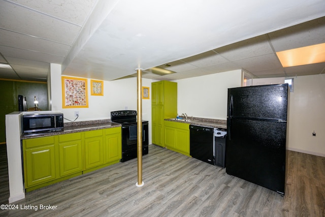 kitchen with sink, black appliances, light hardwood / wood-style floors, and a paneled ceiling