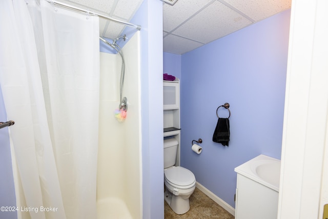 bathroom with a paneled ceiling, toilet, vanity, and tile patterned floors