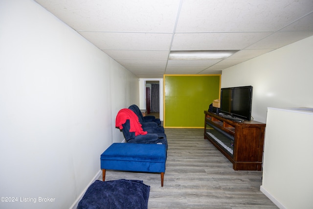 living area featuring a paneled ceiling and wood-type flooring