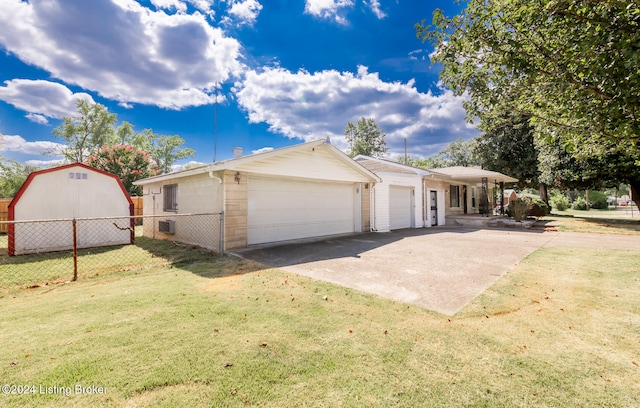 view of front facade with a storage shed, a garage, and a front yard