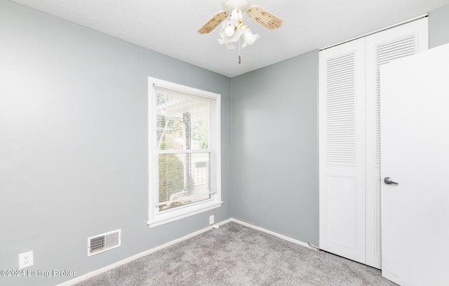 unfurnished bedroom featuring a closet, ceiling fan, and light colored carpet