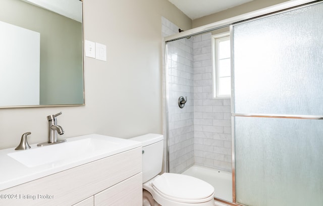 bathroom with a shower with door, vanity, and toilet