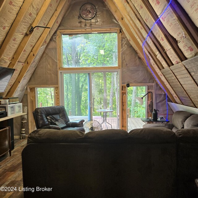 living room with a wealth of natural light, lofted ceiling, and hardwood / wood-style floors