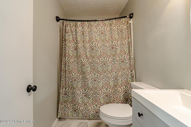 bathroom with vanity, a textured ceiling, toilet, and curtained shower