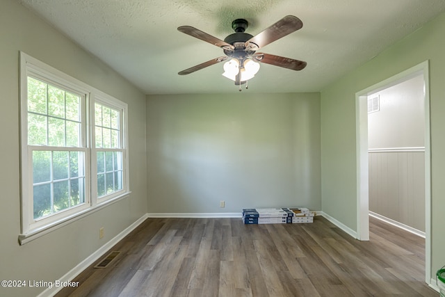 empty room with ceiling fan, a textured ceiling, and light hardwood / wood-style floors