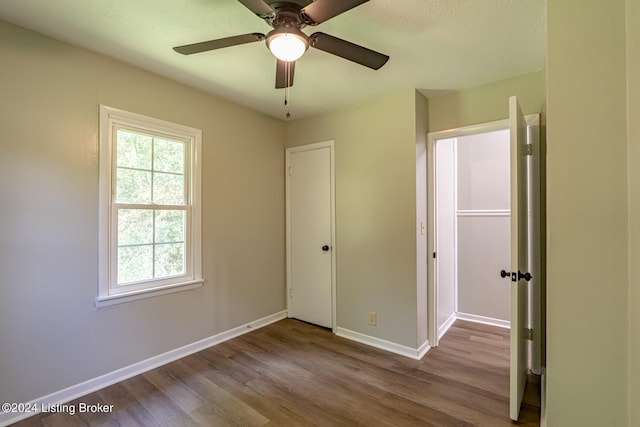 unfurnished bedroom featuring ceiling fan, a closet, and light hardwood / wood-style floors