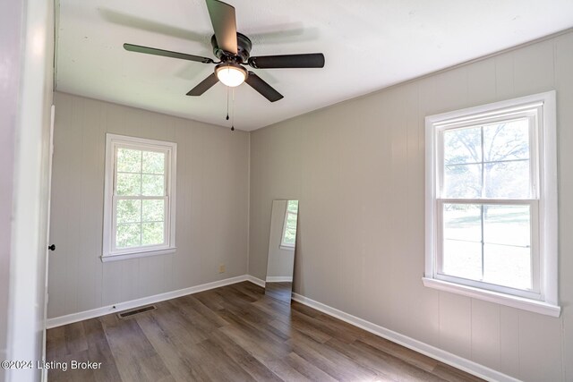 empty room featuring wood-type flooring, ceiling fan, and a wealth of natural light