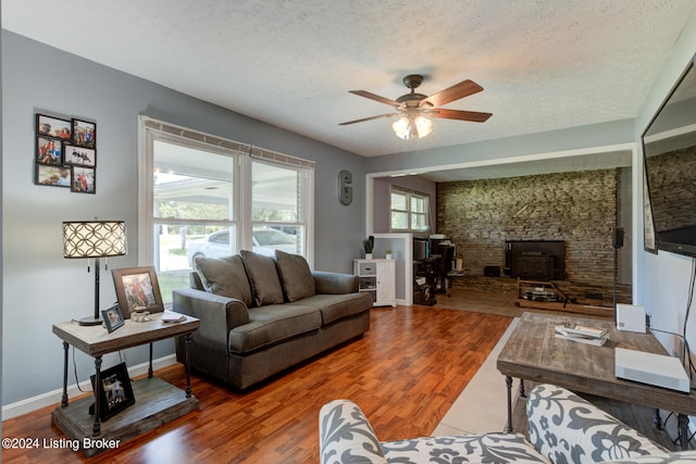 living room with a wealth of natural light, a textured ceiling, and hardwood / wood-style floors