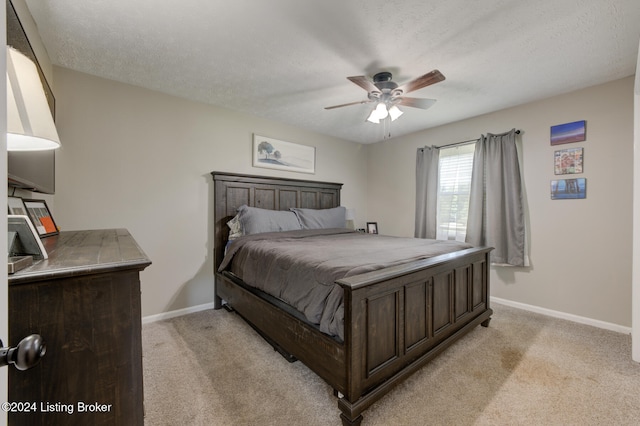 carpeted bedroom with ceiling fan and a textured ceiling