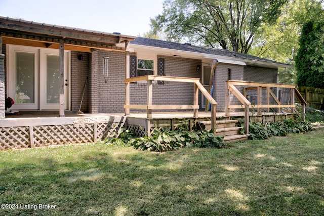 rear view of house with a wooden deck and a yard