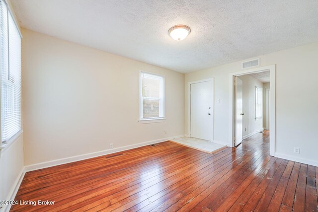 unfurnished bedroom featuring wood-type flooring and a textured ceiling