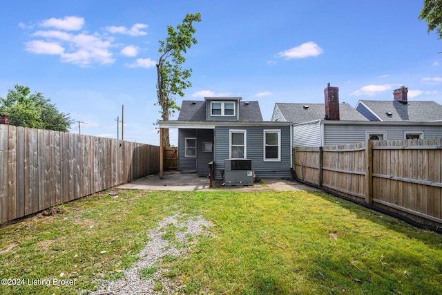 rear view of house featuring a patio area, central air condition unit, and a lawn