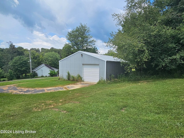 view of yard featuring a garage and an outbuilding