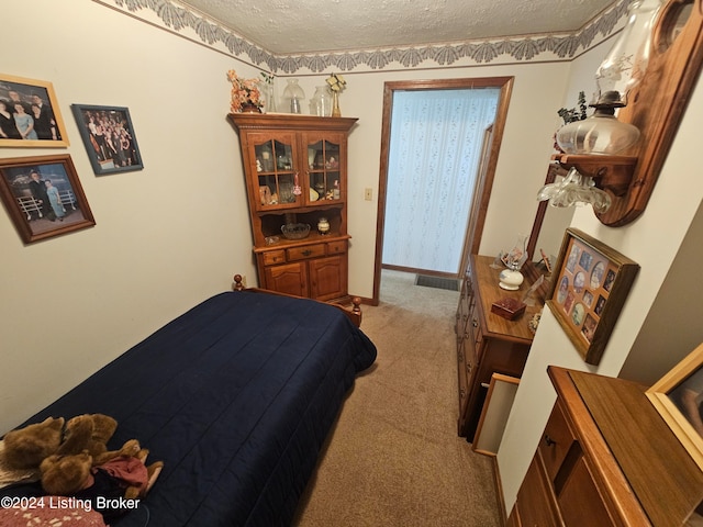 bedroom with a textured ceiling and light carpet