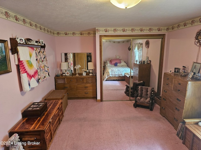 bedroom with a closet, carpet floors, and a textured ceiling