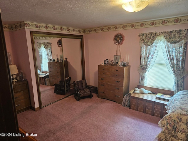 carpeted bedroom featuring a textured ceiling and a closet