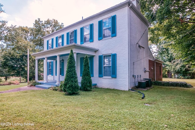 view of front facade with a front yard, cooling unit, and covered porch