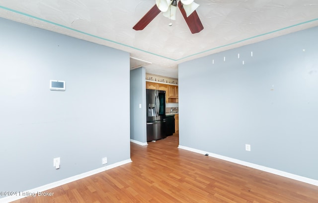 empty room featuring ceiling fan, light hardwood / wood-style flooring, and a textured ceiling