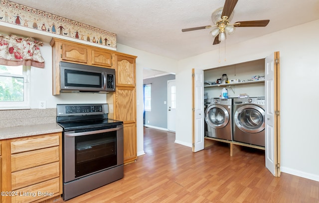 kitchen with appliances with stainless steel finishes, ceiling fan, washer and clothes dryer, and light wood-type flooring