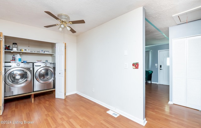 laundry area featuring a textured ceiling, ceiling fan, hardwood / wood-style floors, and washer and clothes dryer