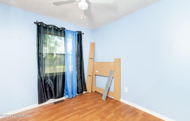 spare room featuring a textured ceiling, ceiling fan, and hardwood / wood-style floors