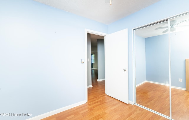 unfurnished bedroom featuring a closet, a textured ceiling, and wood-type flooring