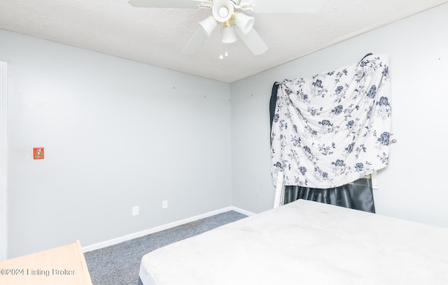 carpeted bedroom featuring ceiling fan and a textured ceiling