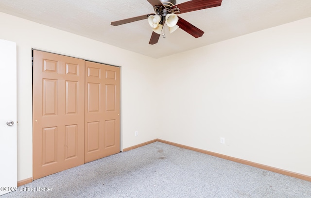 unfurnished bedroom with ceiling fan, a closet, and carpet