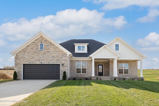 view of front facade featuring a front yard, a garage, and covered porch