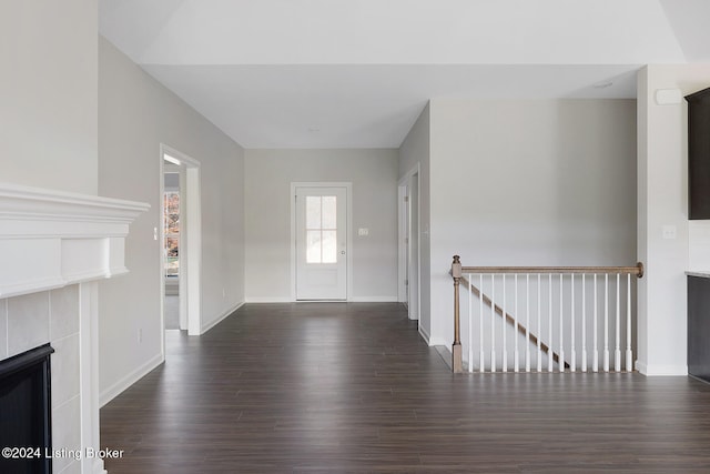 foyer entrance featuring dark hardwood / wood-style flooring and a fireplace